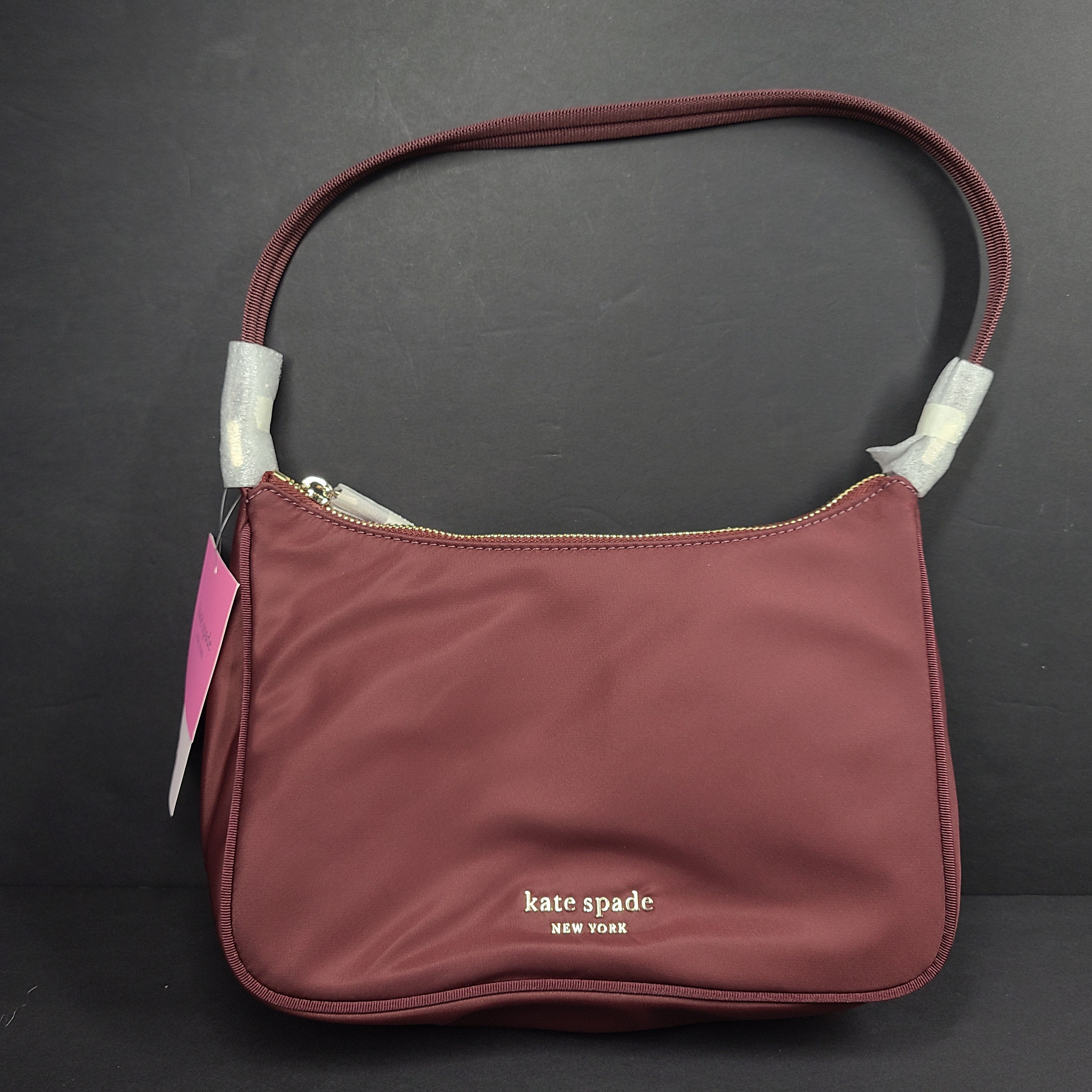 Kate Spade Sam shoulder bag in dark merlot with a refined silhouette and adjustable strap.