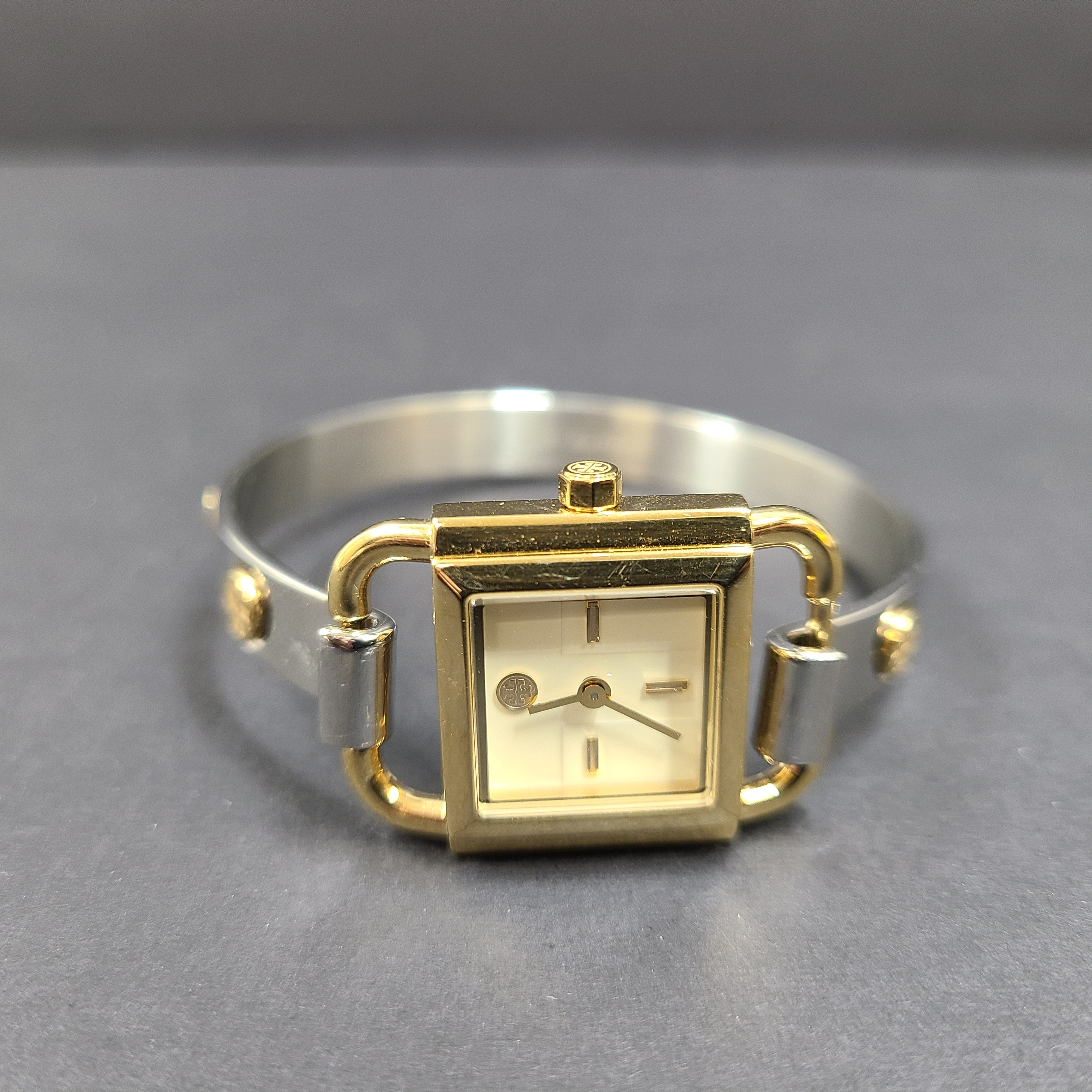 Tory Burch two-tone stainless steel bracelet watch TBW7257 with round dial and logo engraving.