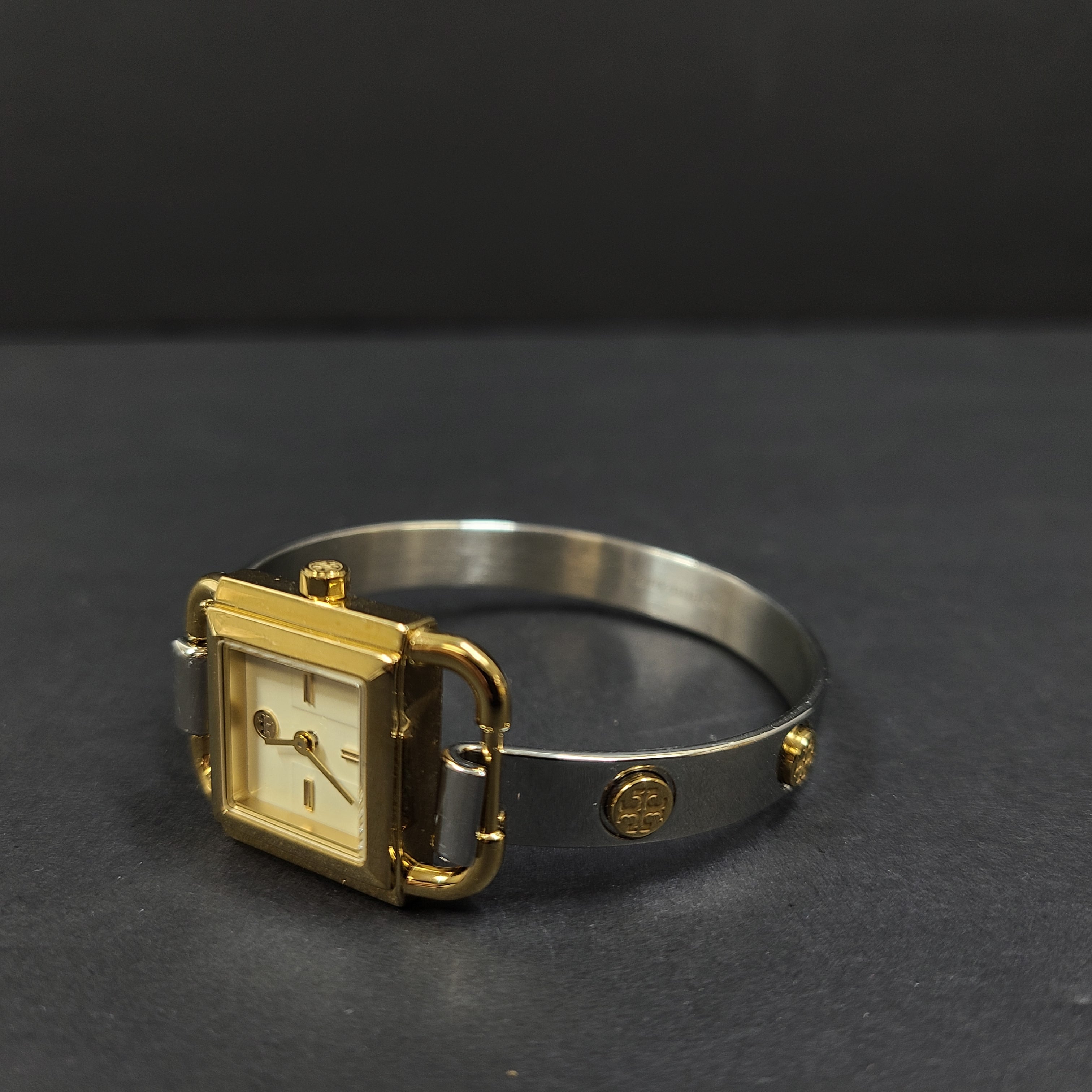 Tory Burch two-tone stainless steel bracelet watch TBW7257 with round dial and logo engraving.