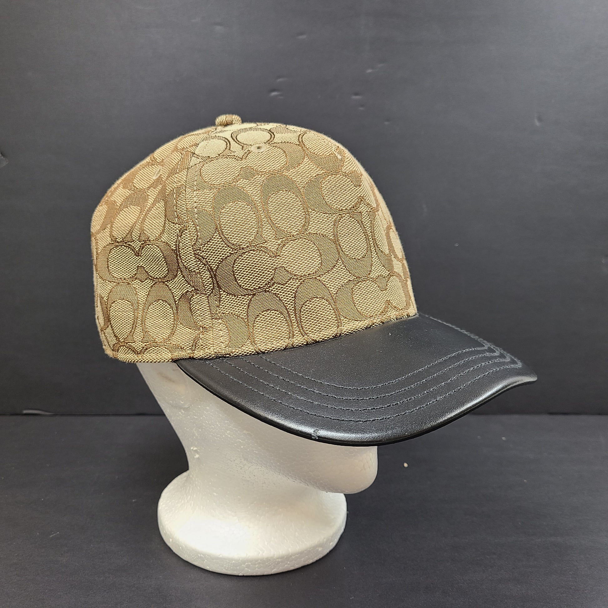 Tan and black Coach baseball cap in M/L size with canvas body and leather brim.