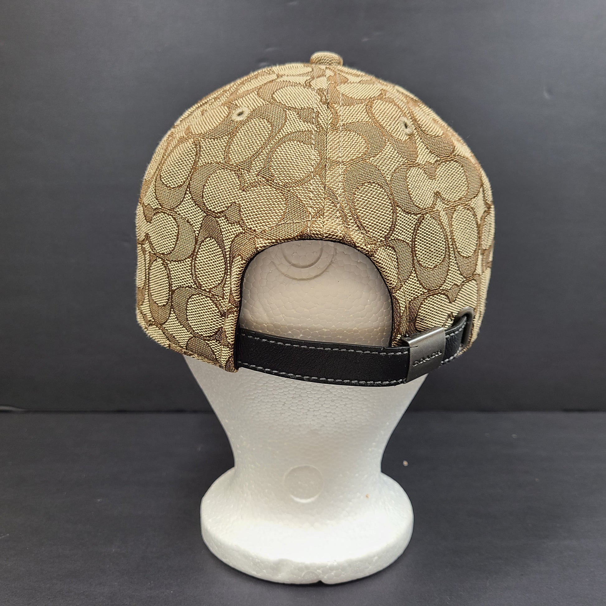 Tan and black Coach baseball cap in M/L size with canvas body and leather brim.