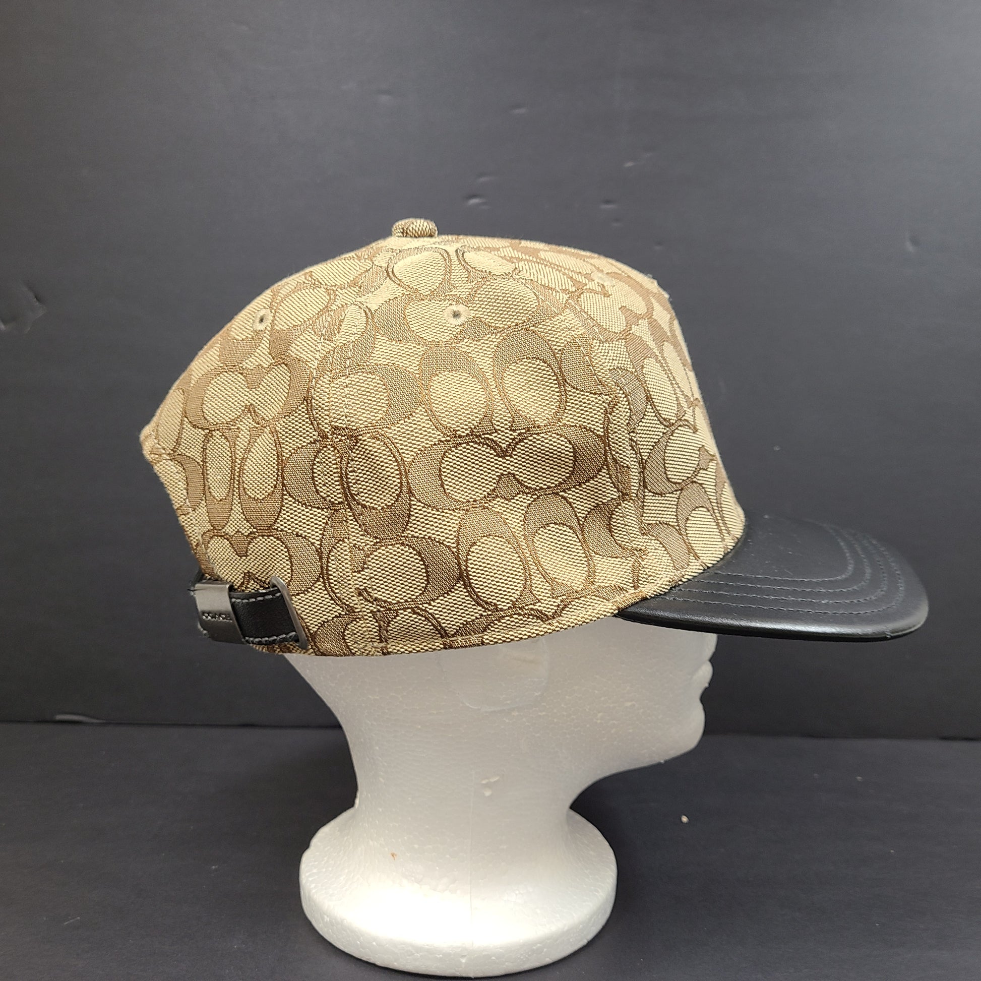 Tan and black Coach baseball cap in M/L size with canvas body and leather brim.