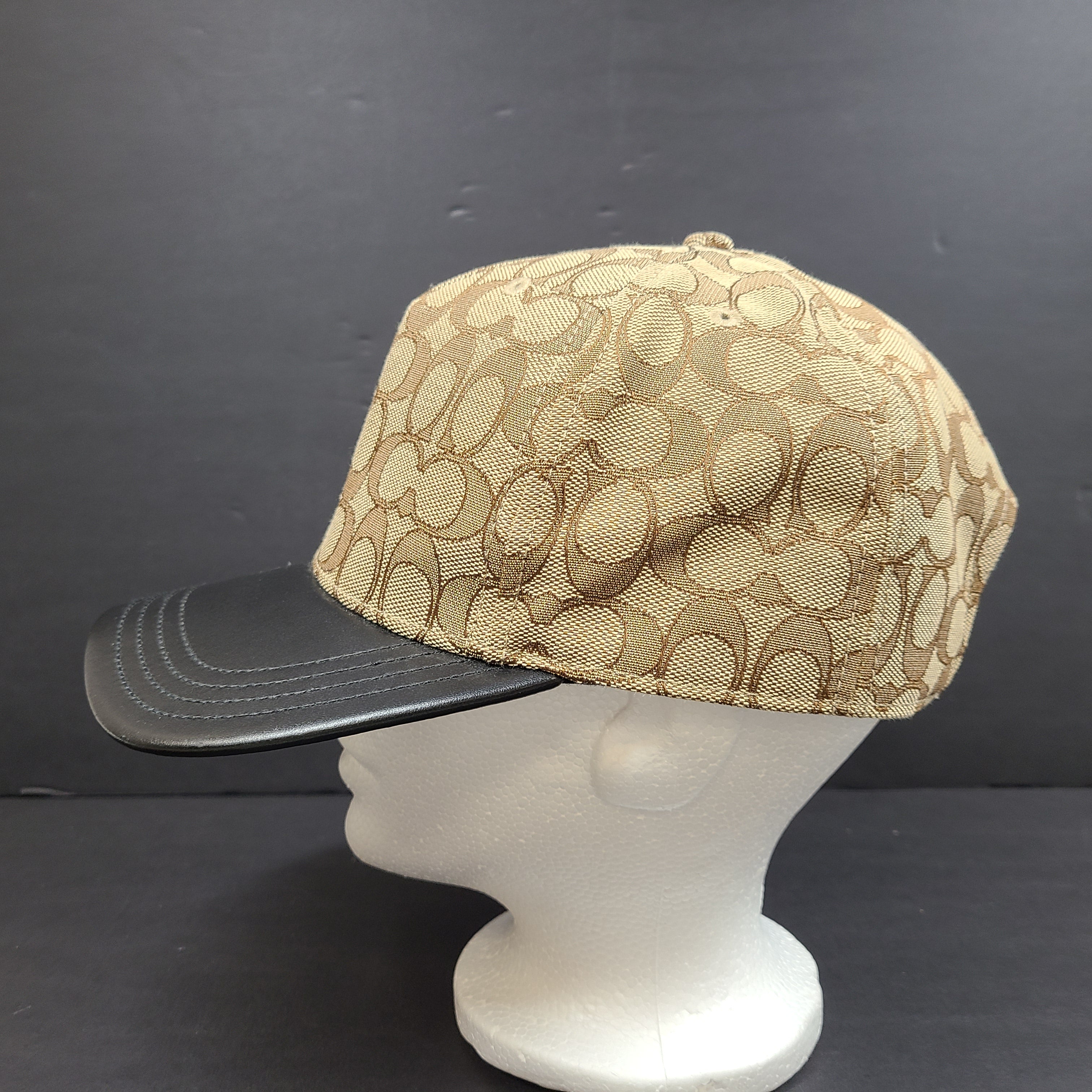 Tan and black Coach baseball cap in M/L size with canvas body and leather brim.