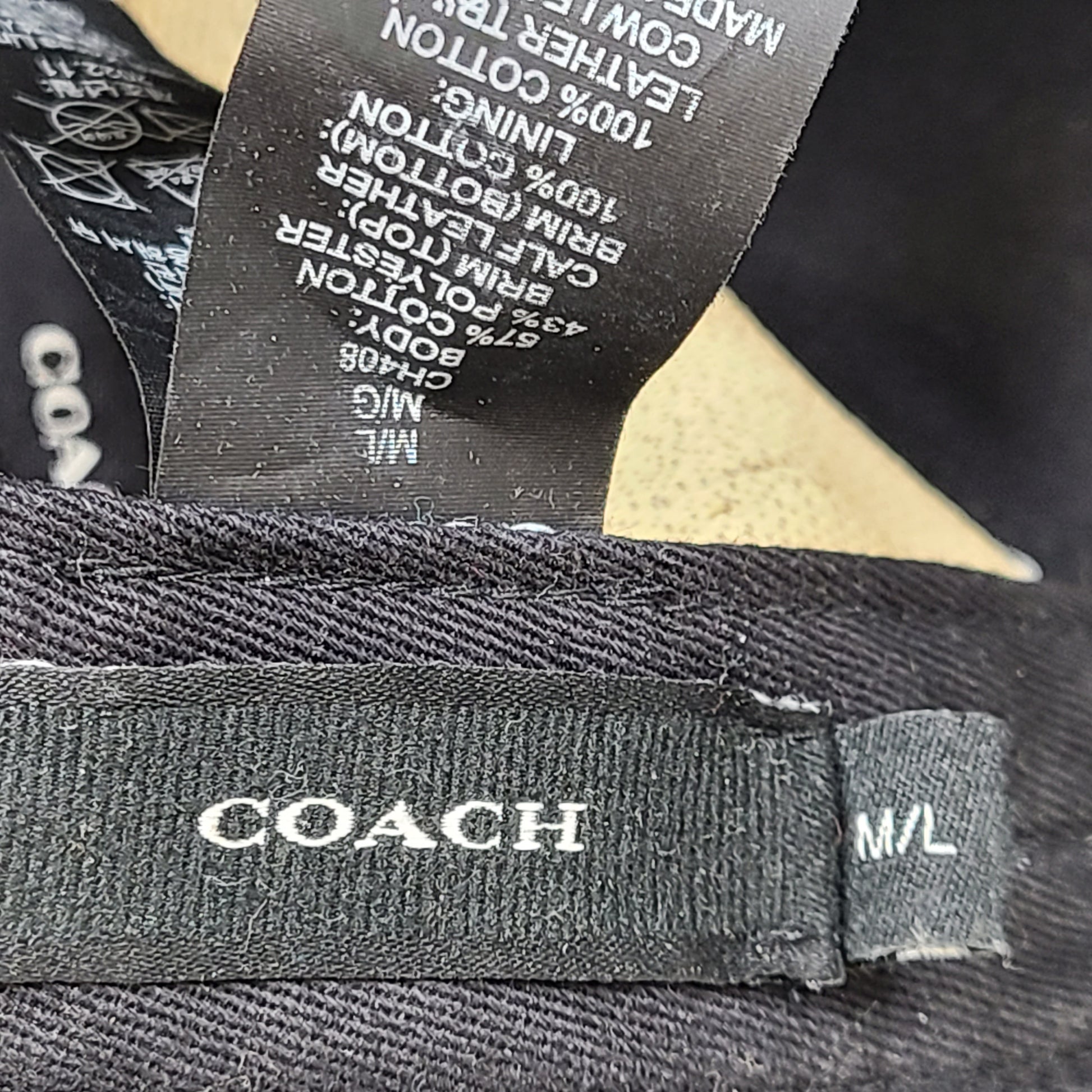 Tan and black Coach baseball cap in M/L size with canvas body and leather brim.