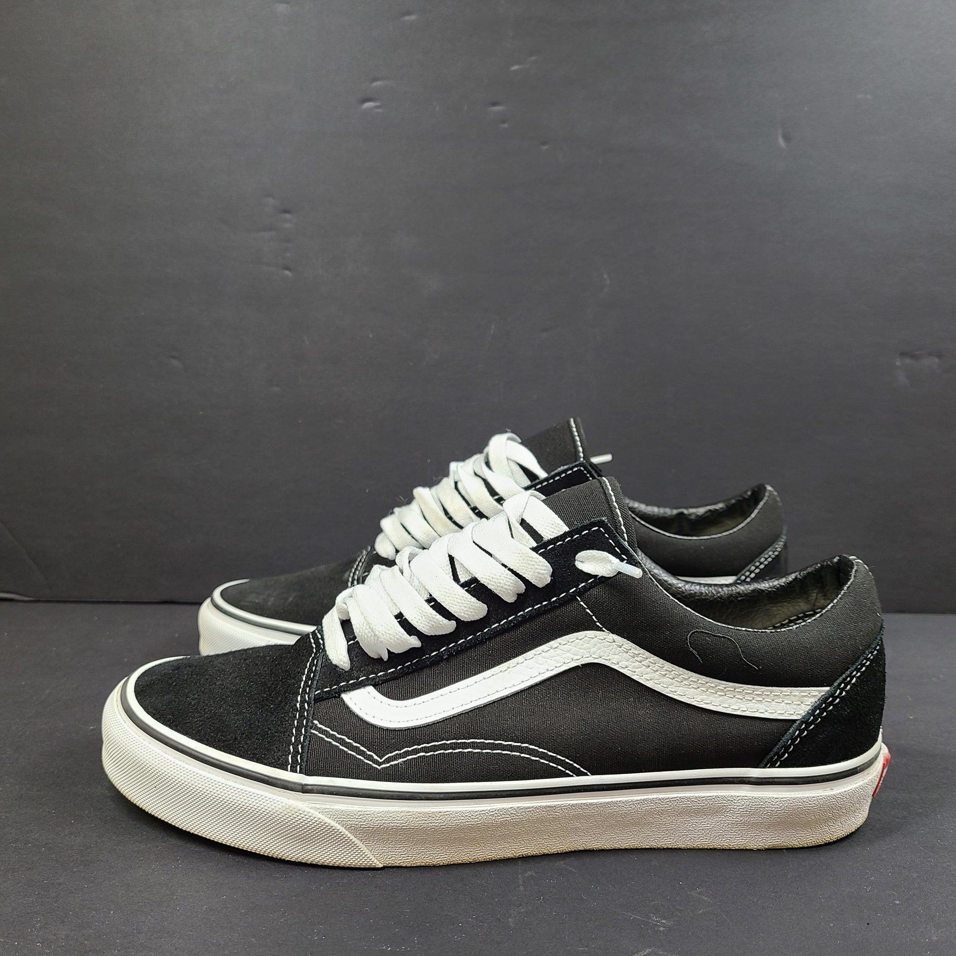 Low-top Vans Old Skool skate shoe in black with a white side stripe and vulcanized sole.