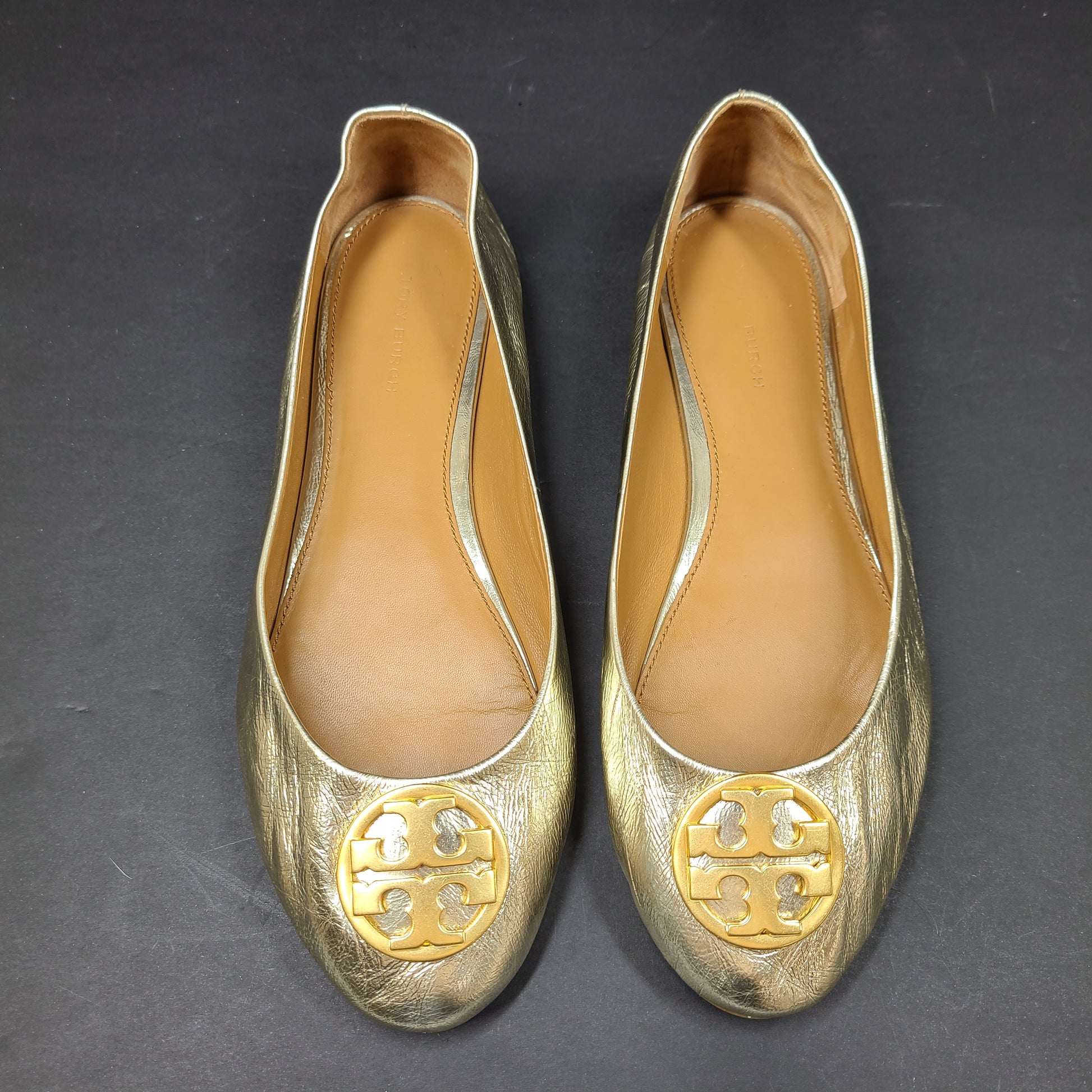 Gold leather Tory Burch flats with rubber outsole and minor creasing, size 8½M.