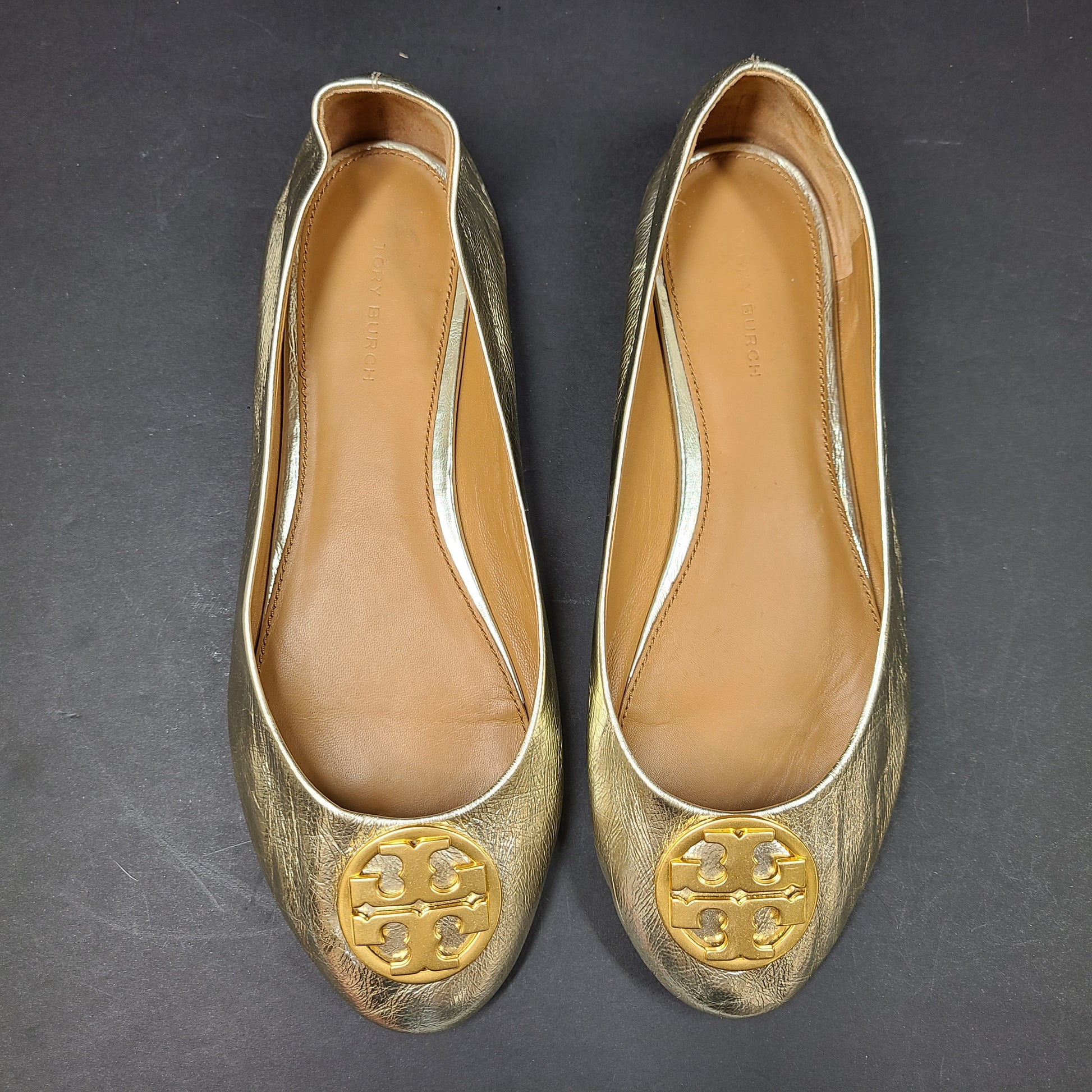 Gold leather Tory Burch flats with rubber outsole and minor creasing, size 8½M.
