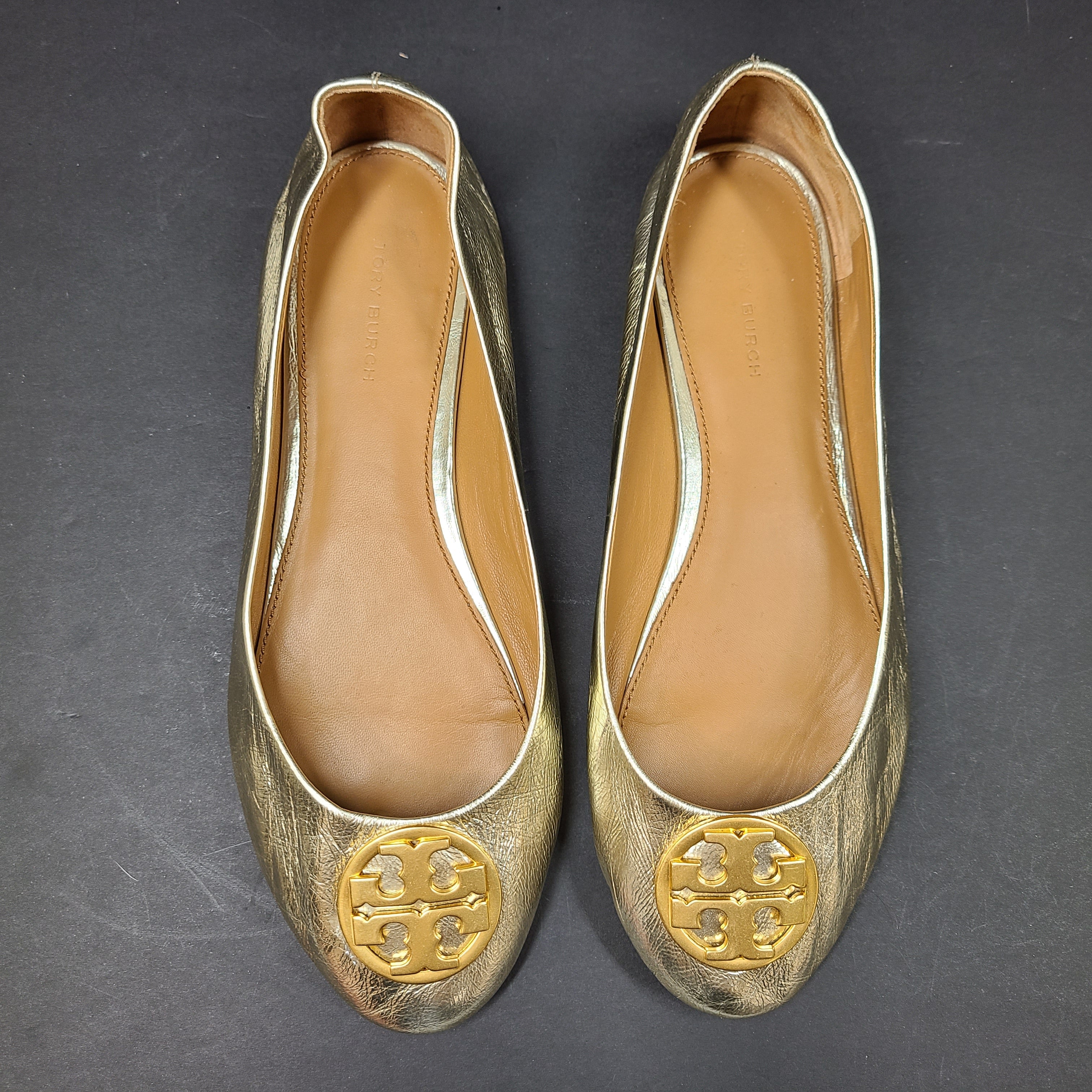 Gold leather Tory Burch flats with rubber outsole and minor creasing, size 8½M.