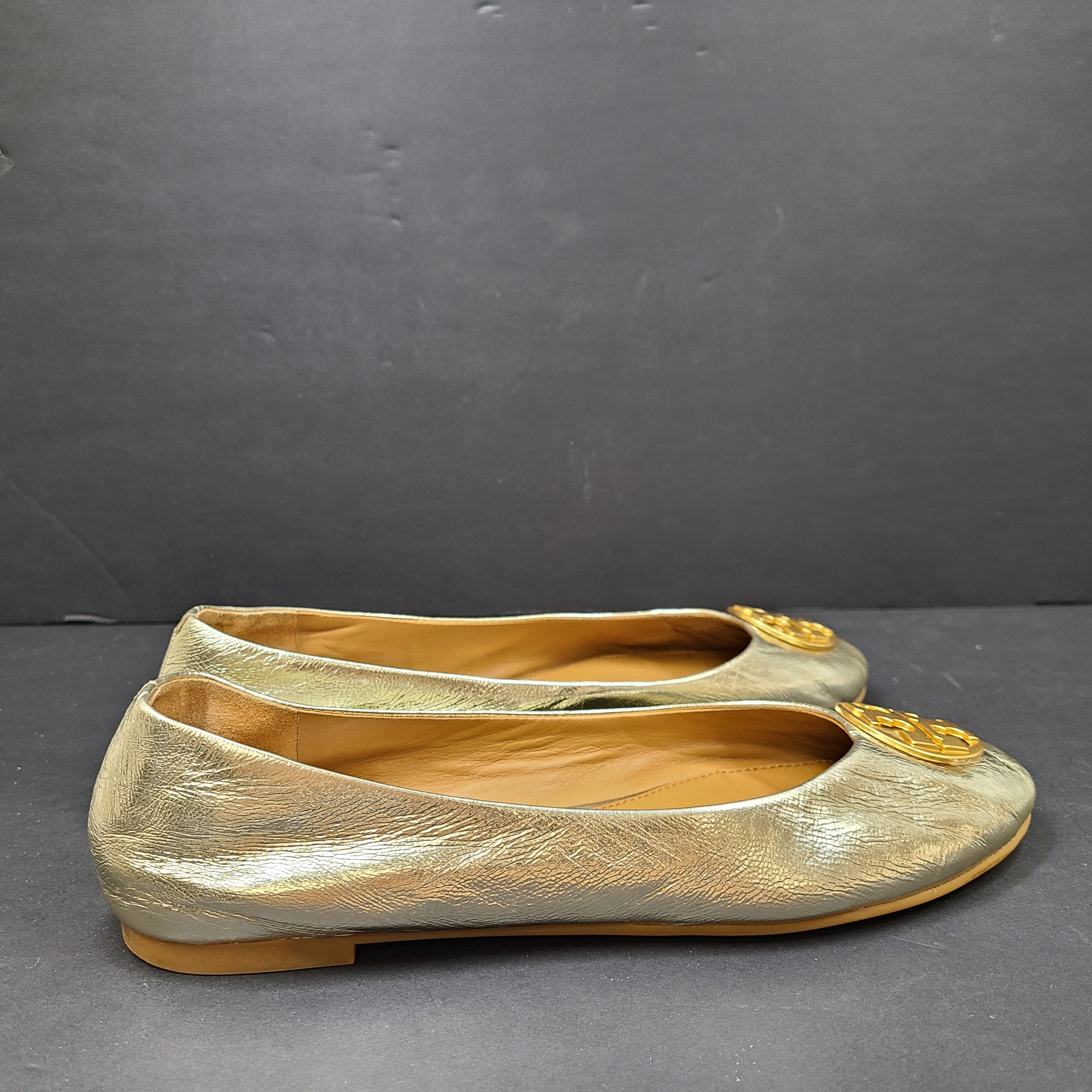 Gold leather Tory Burch flats with rubber outsole and minor creasing, size 8½M.