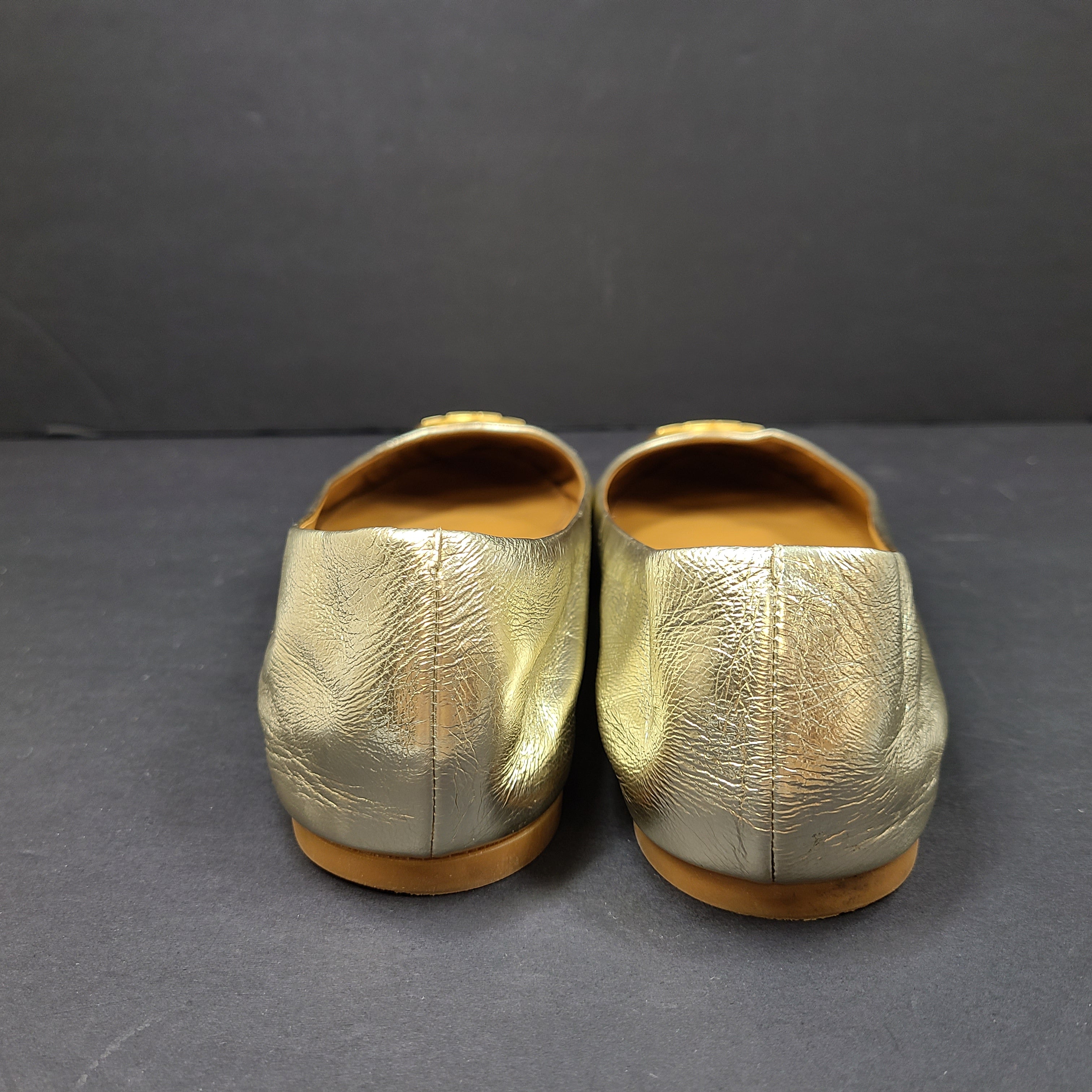 Gold leather Tory Burch flats with rubber outsole and minor creasing, size 8½M.