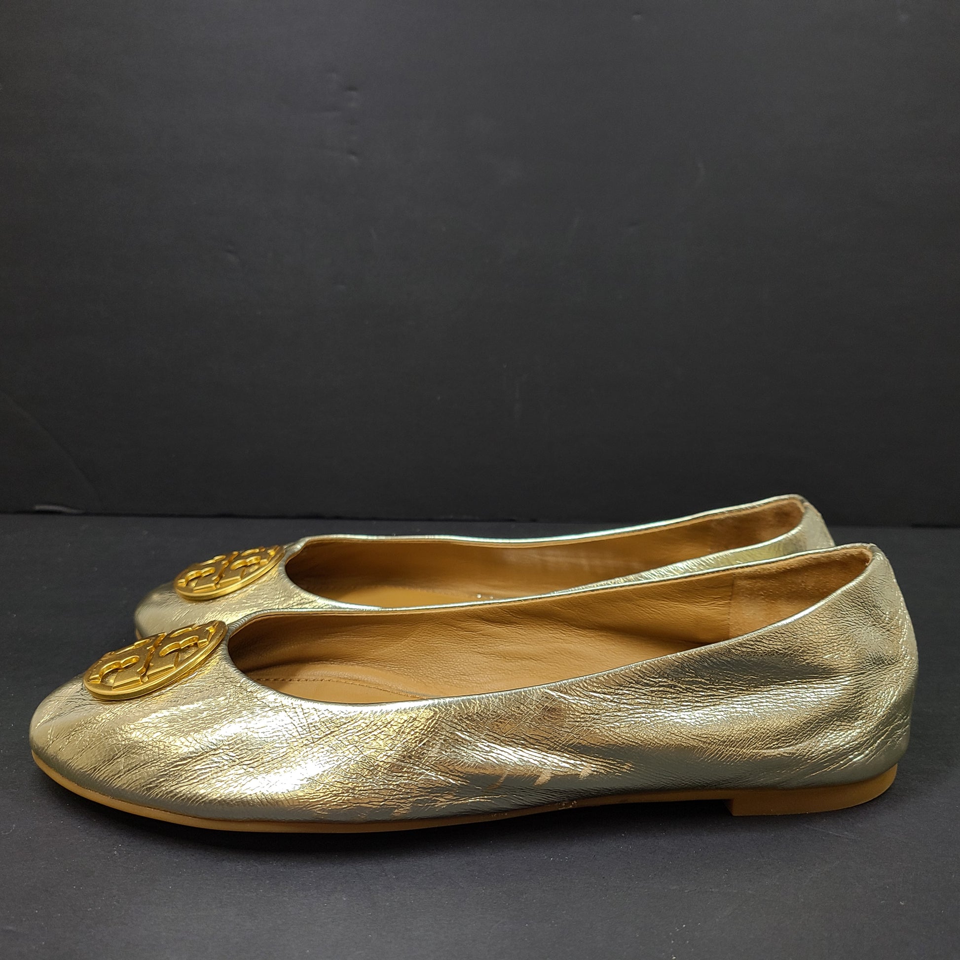 Gold leather Tory Burch flats with rubber outsole and minor creasing, size 8½M.