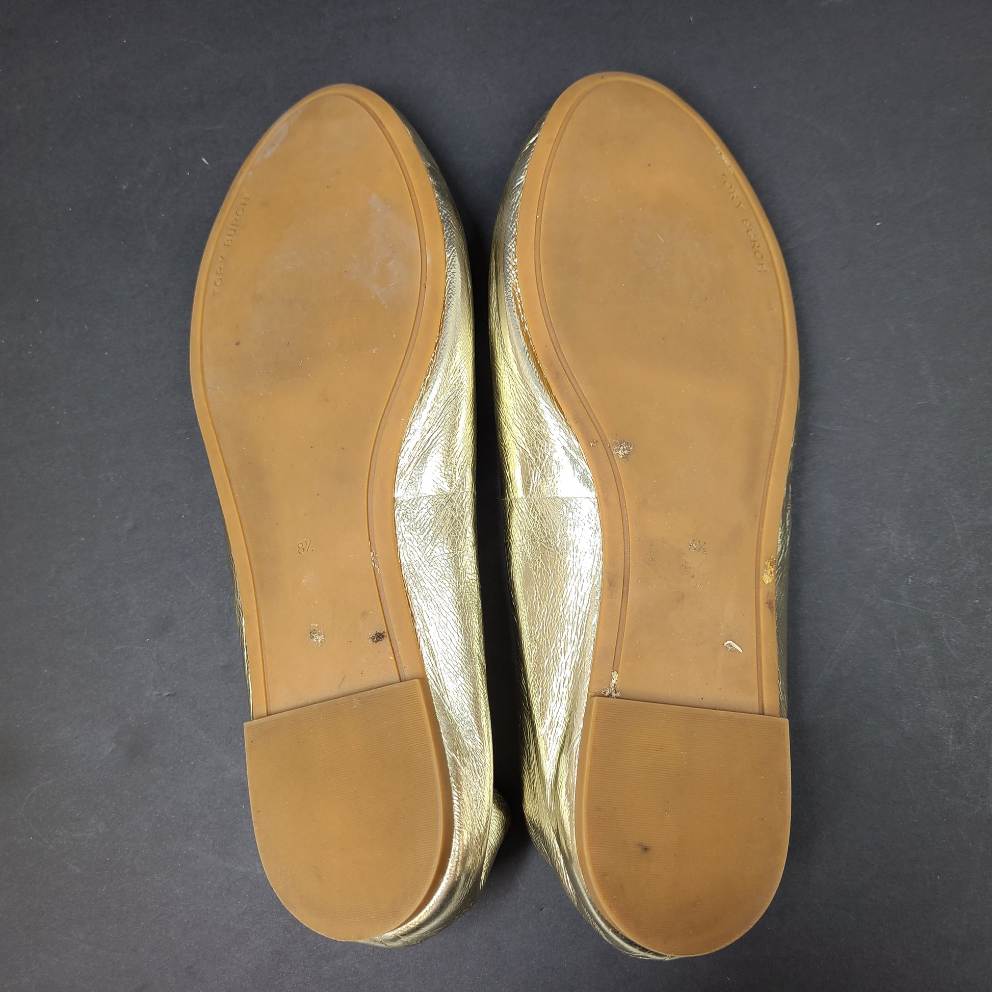 Gold leather Tory Burch flats with rubber outsole and minor creasing, size 8½M.