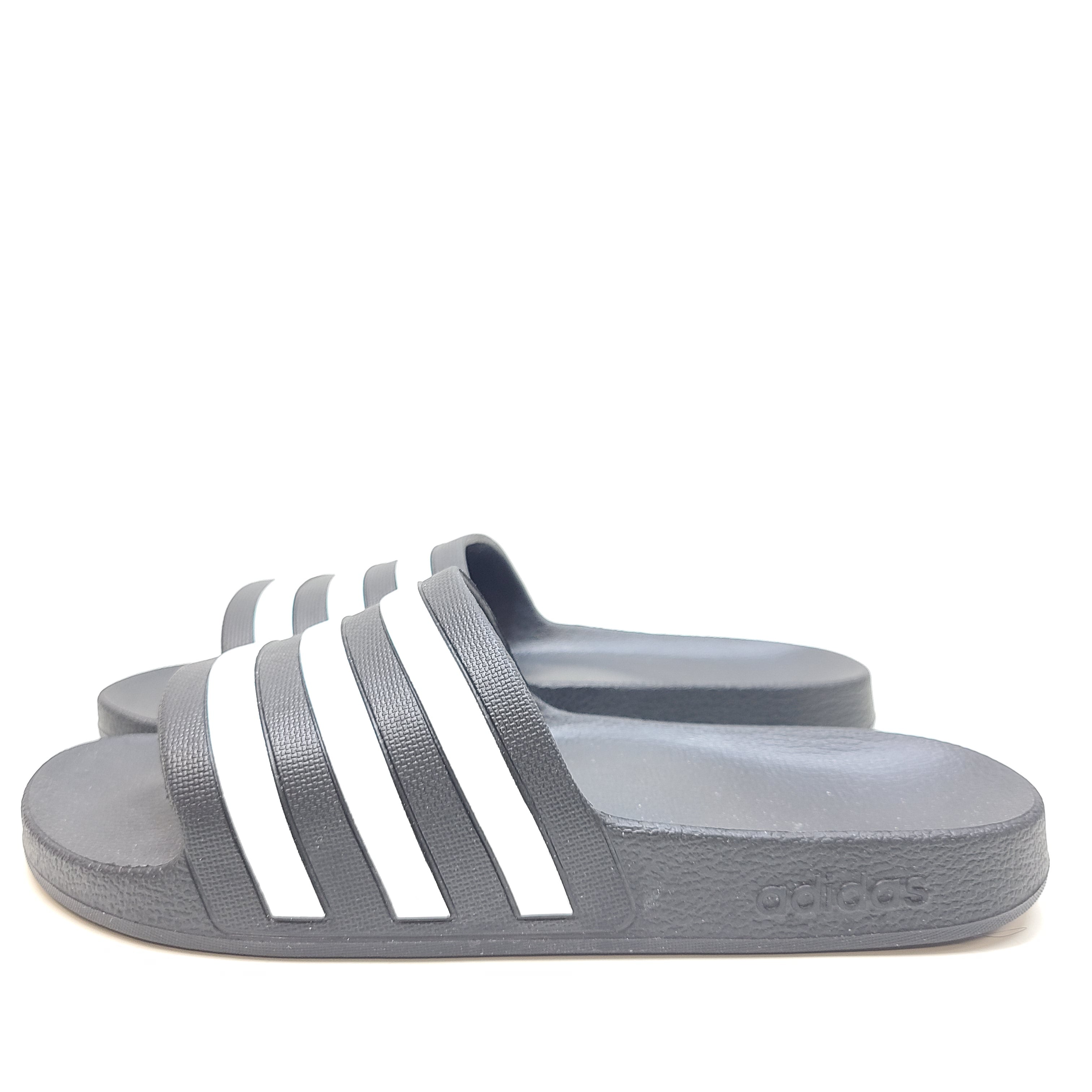 A black Adidas Adilette slide with white three-stripes and a cushioned footbed in UK size 7 (US M 8).