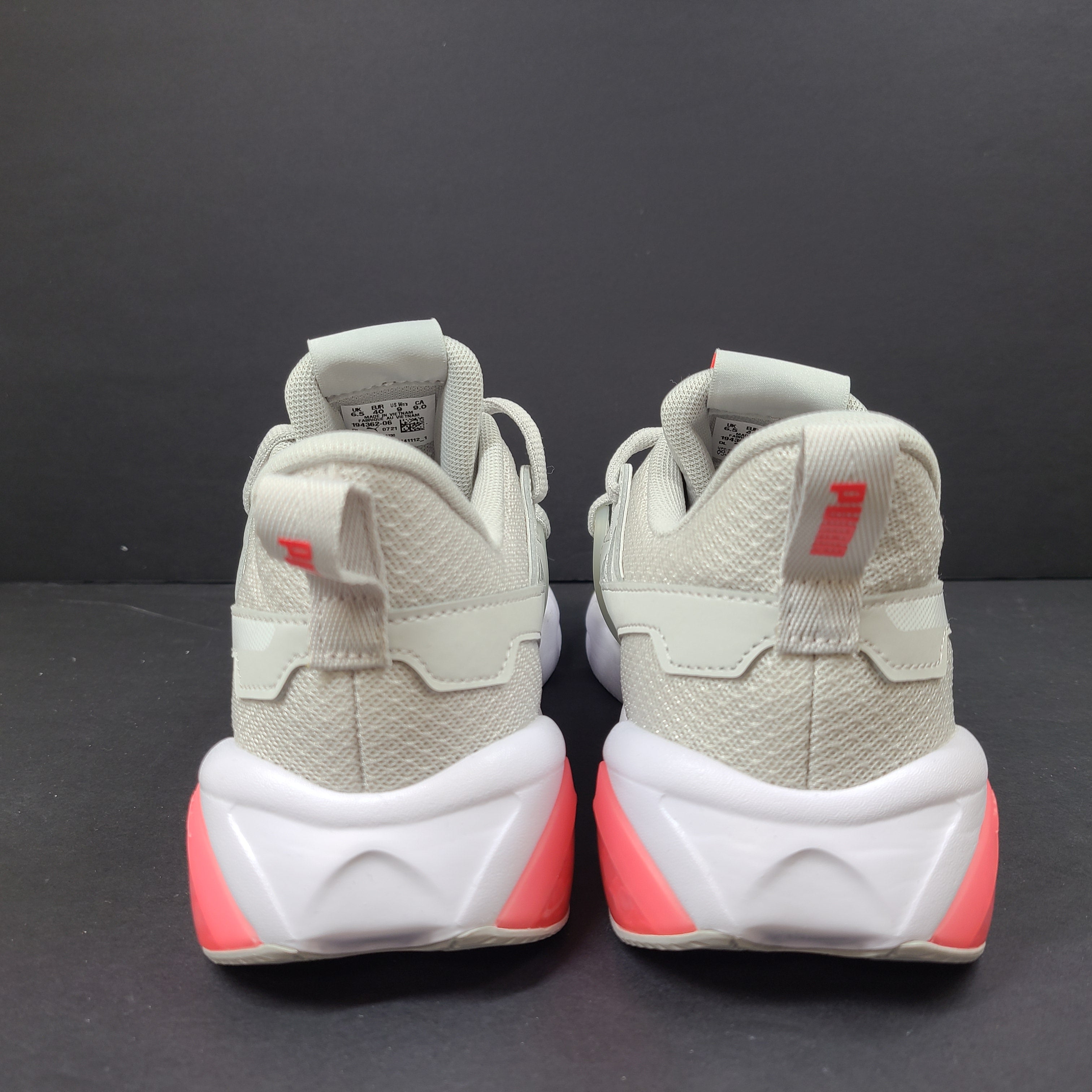 Puma SOFTFOAM women's sneaker in light gray and coral with cushioned midsole for everyday comfort.