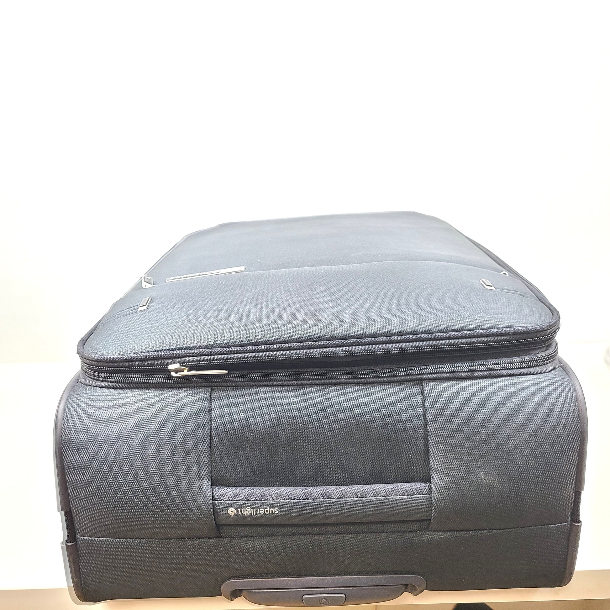 Black Samsonite Super Light spinner suitcase designed for lightweight travel and effortless maneuvering.