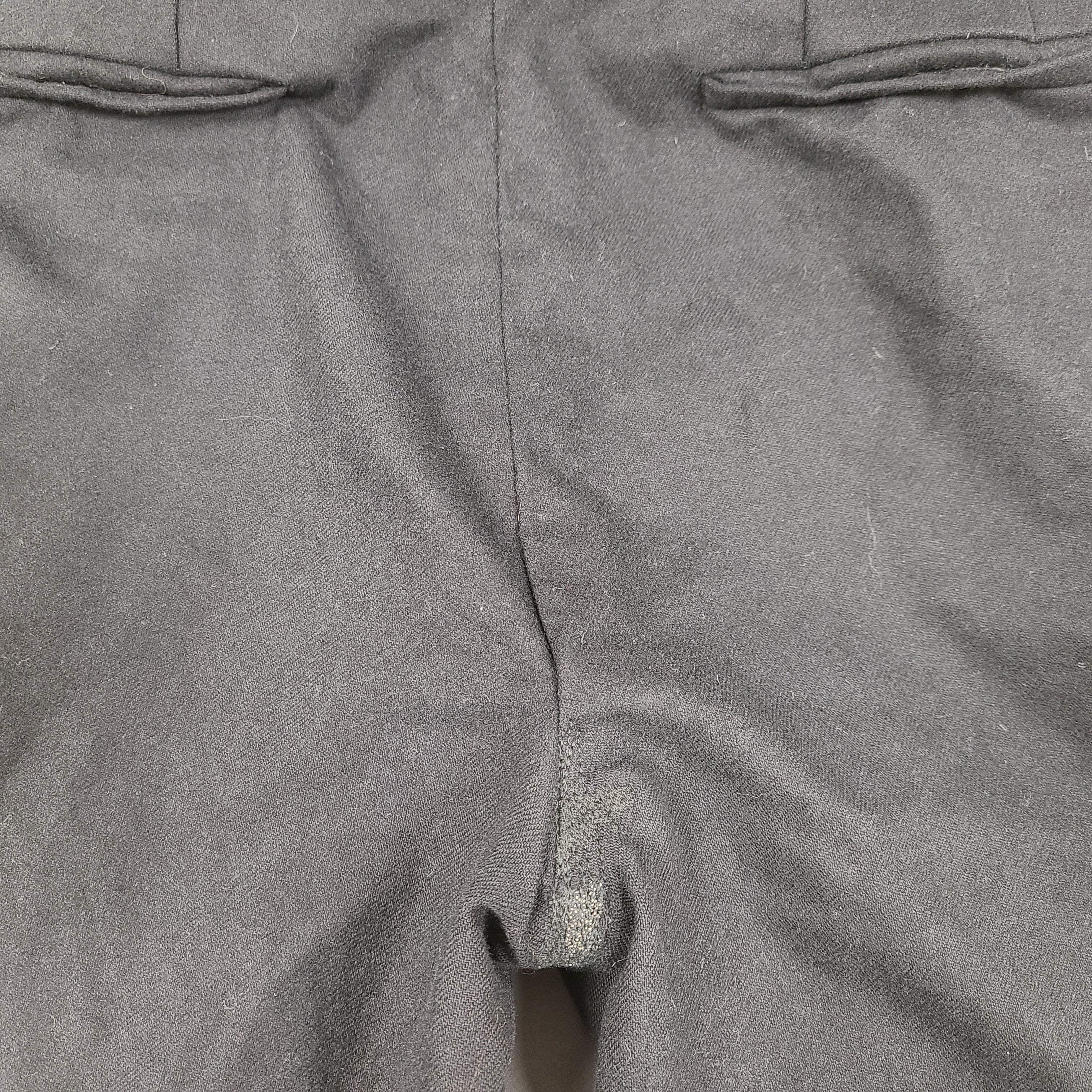 Black Givenchy wool trousers, size 52, with tailored straight-leg styling.