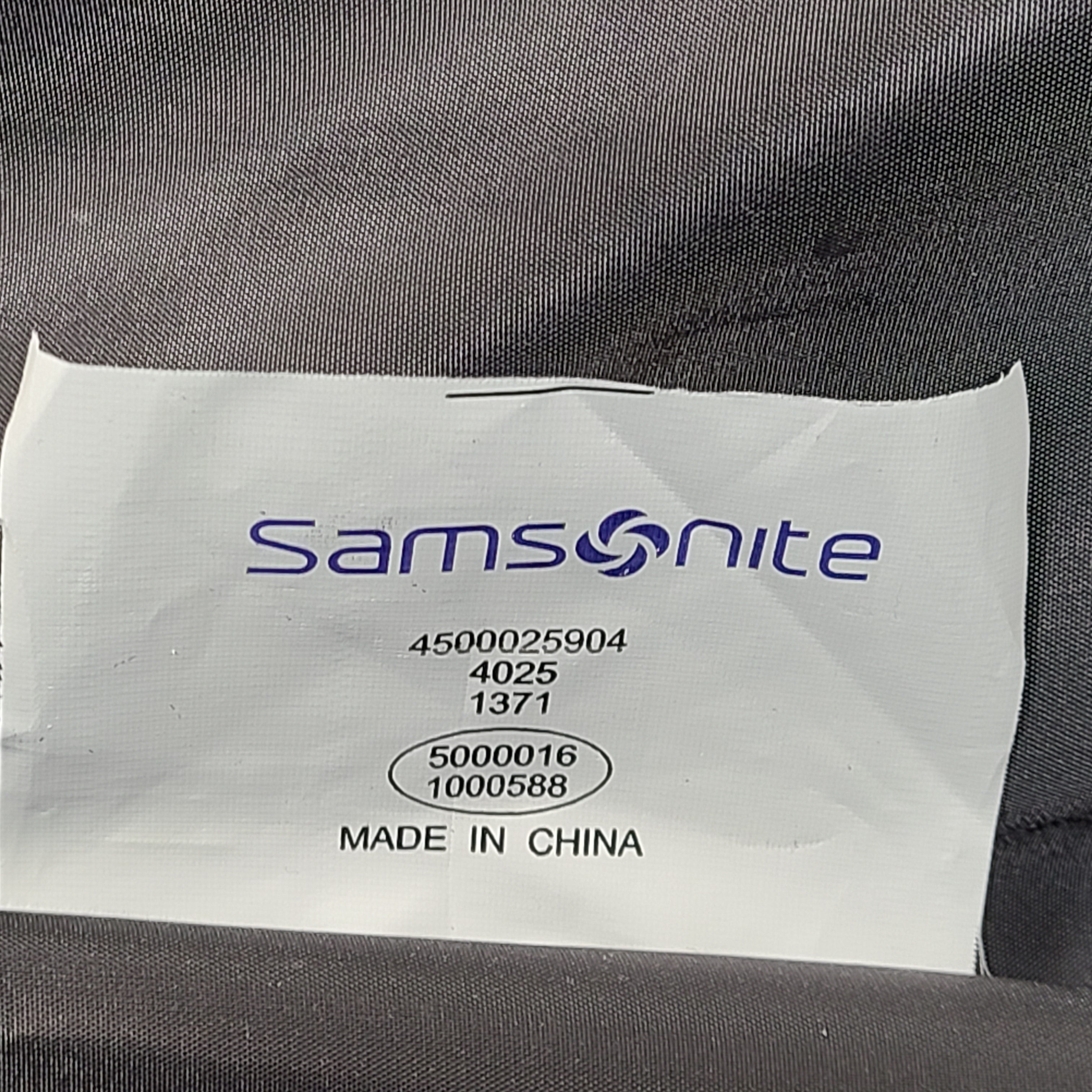 Green Samsonite suitcase model 4500025904 with scuff marks on wheels and handles.