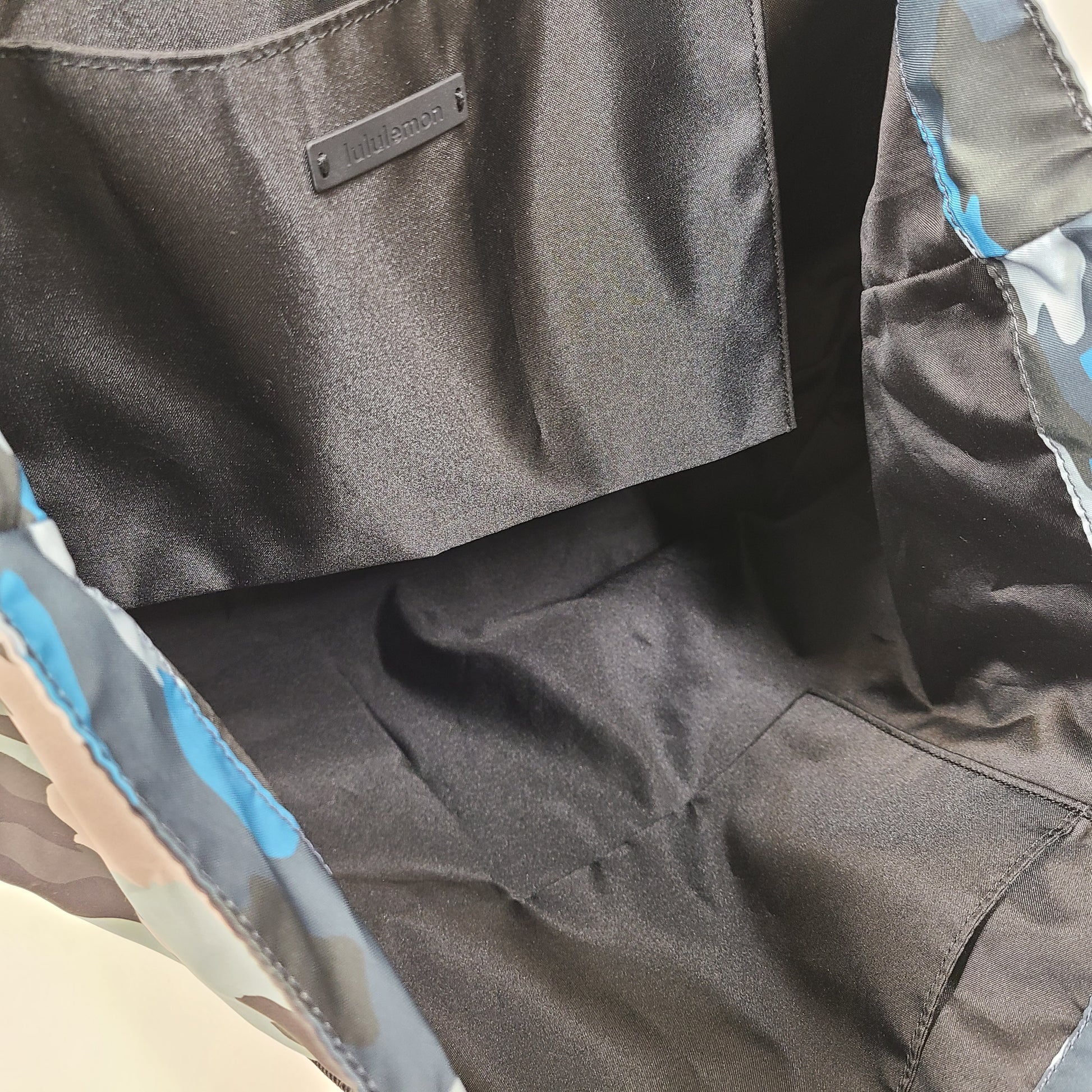 Multicolor Lululemon camouflage tote with pink, brown, green and blue panels and an internal label reading "items of importance".