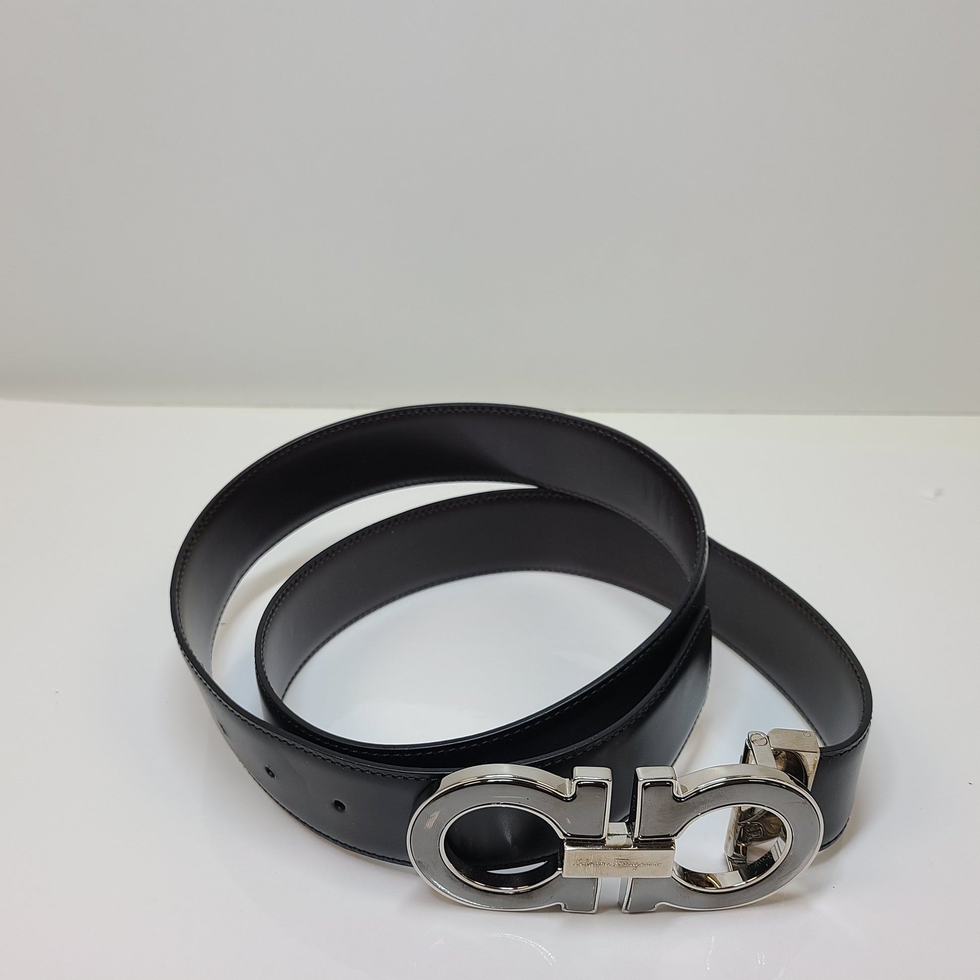 Salvatore Ferragamo black leather belt with refined buckle and Italian craftsmanship.