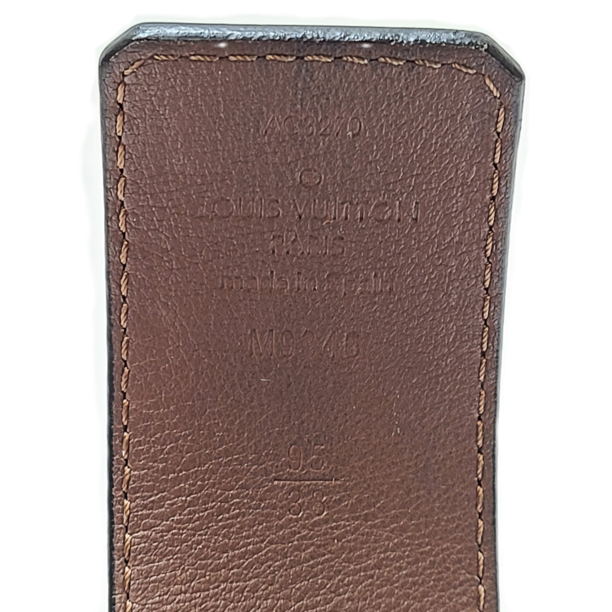 A black Louis Vuitton leather belt with monogram pattern, polished buckle, and Louis Vuitton Paris stamp.