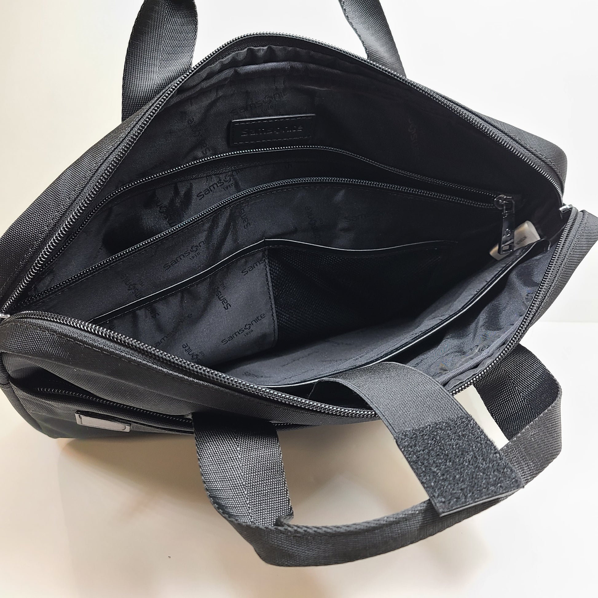 Black Samsonite laptop bag crafted from polyester and microfiber with a slim travel profile and padded laptop compartment.