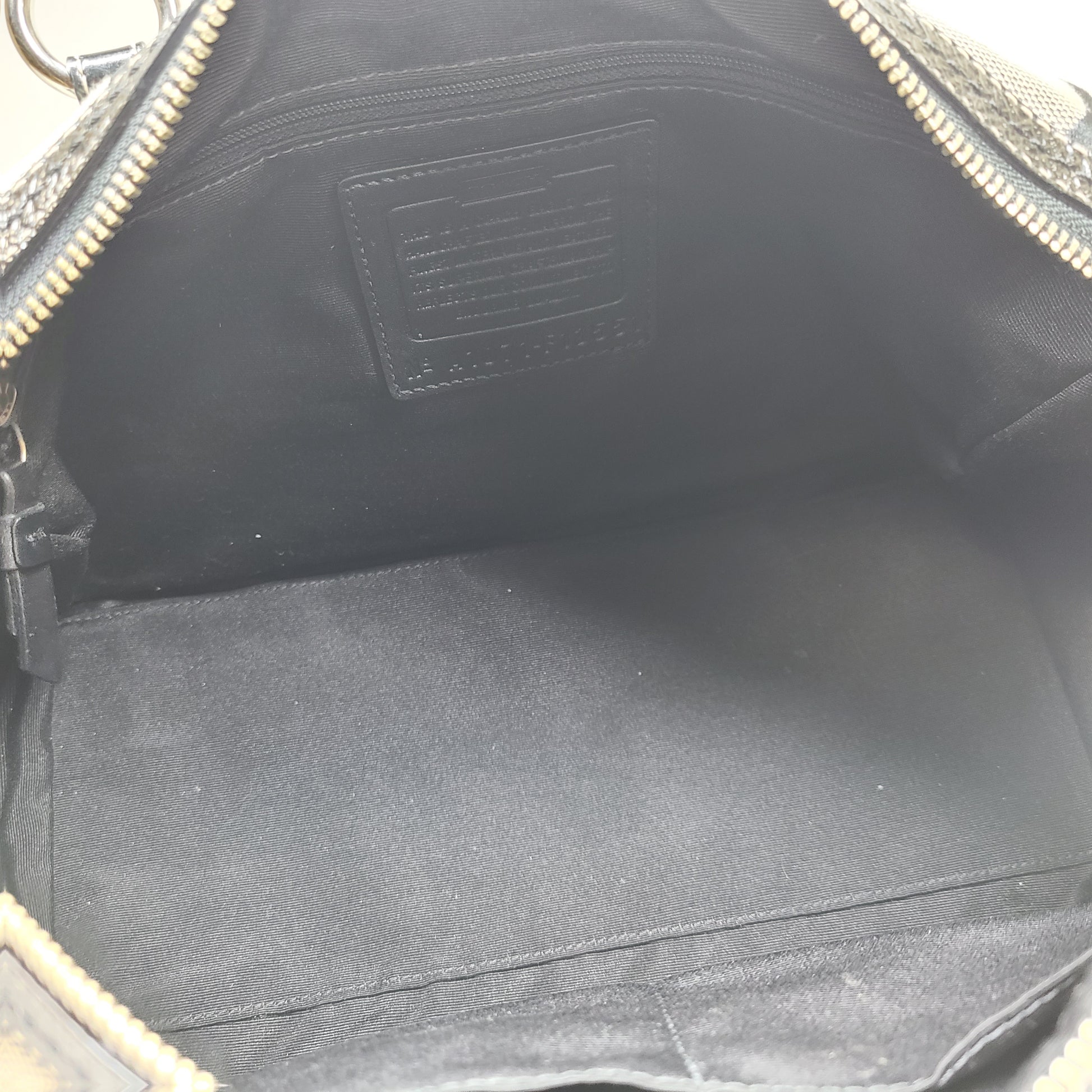 Gray and black Coach satchel with double handles, zip closure, and an interior patch stating handcrafted Coach leather.