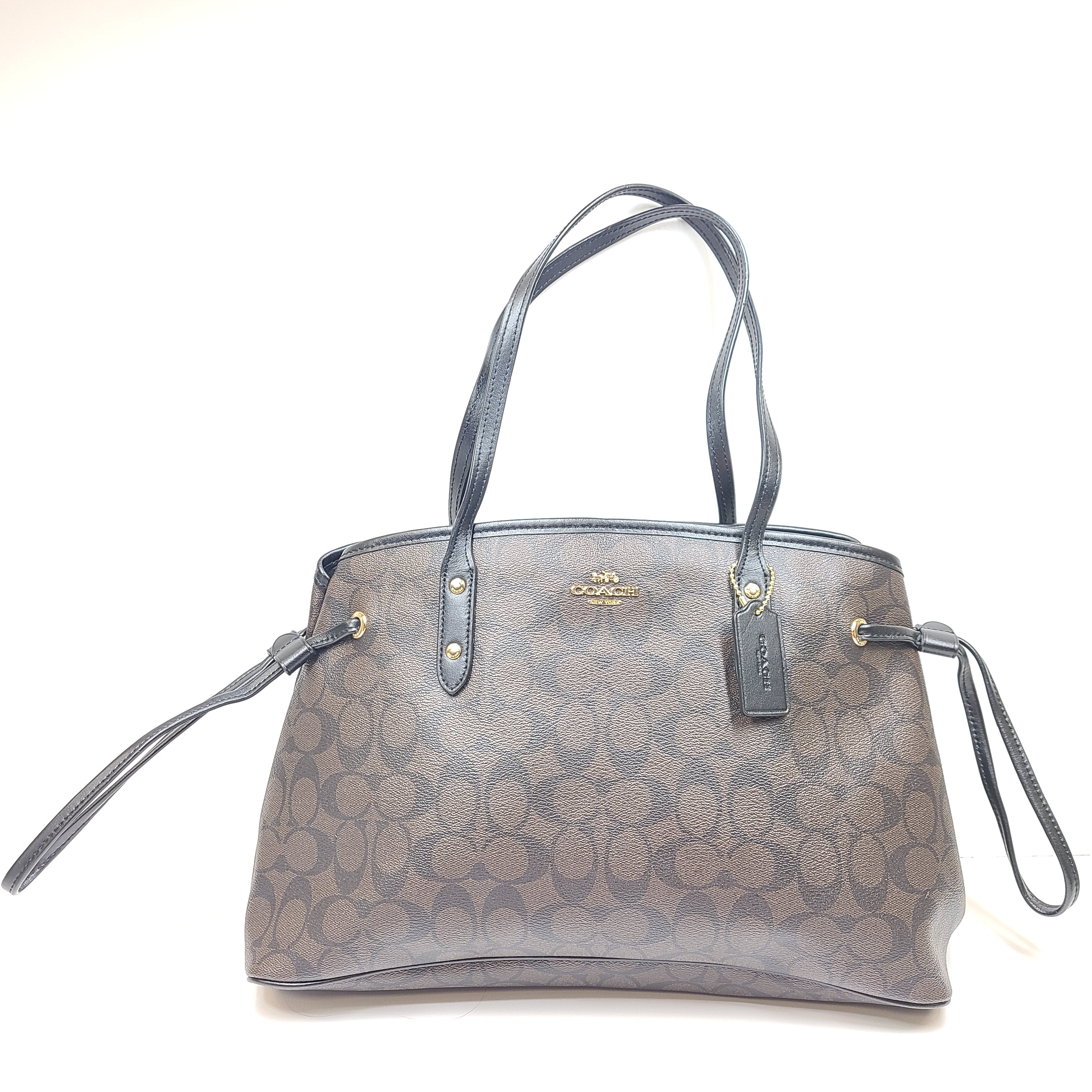 Brown Coach Signature tote with COACH New York interior badge and classic profile.