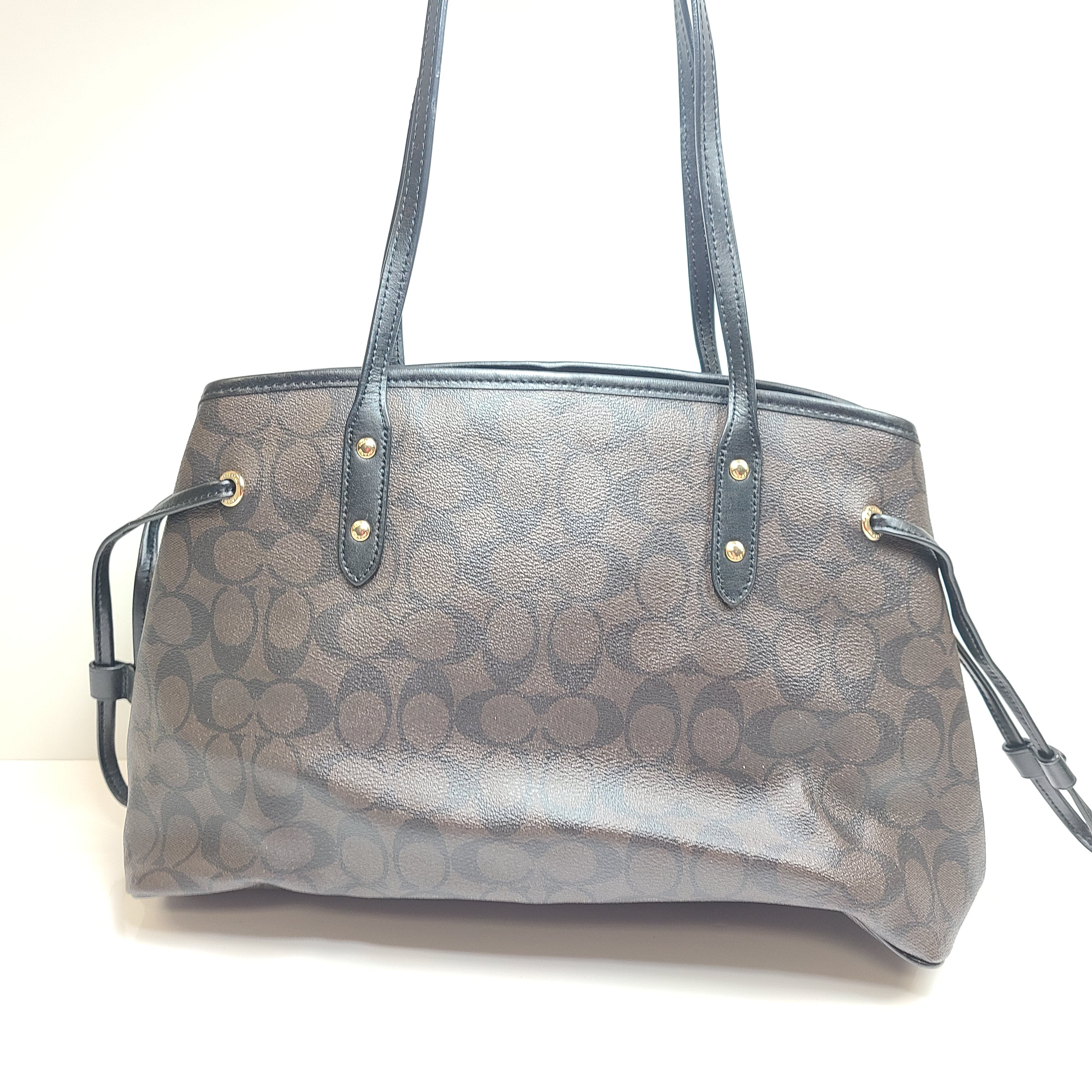 Brown Coach Signature tote with COACH New York interior badge and classic profile.